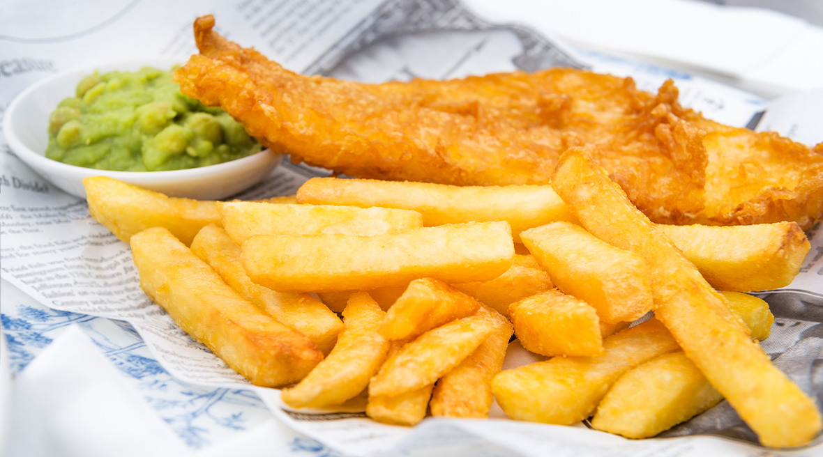 Un fish and chips britannique servi avec une purée de petit pois